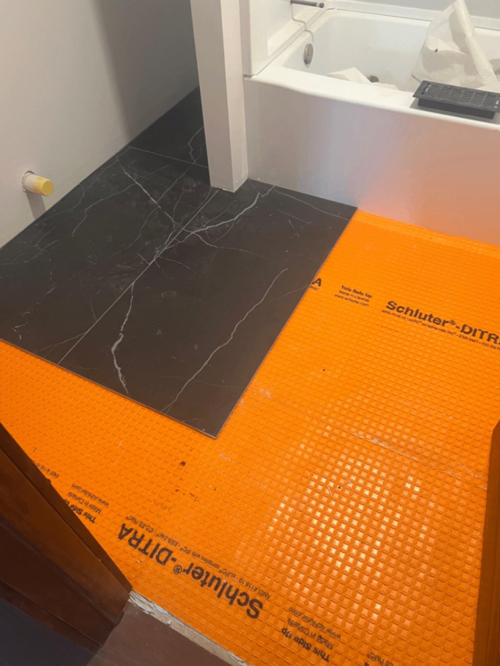 Schluter DITRA uncoupling membrane laid before bathroom tile install