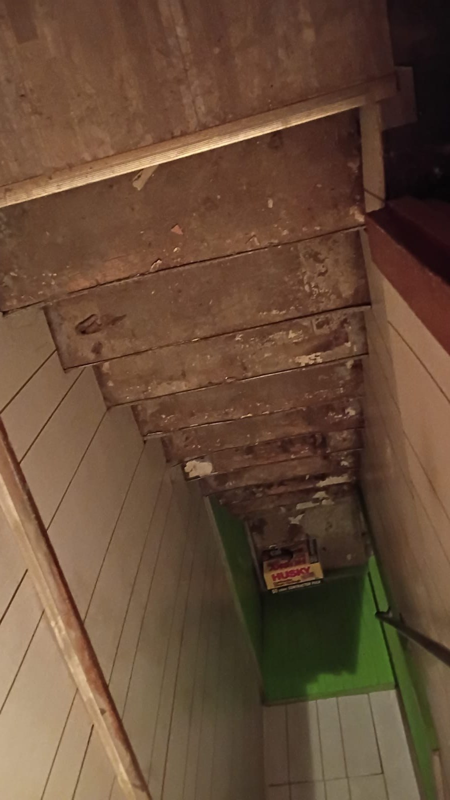 Interior basement stairwell stripped down to bare wood treads during a full home renovation